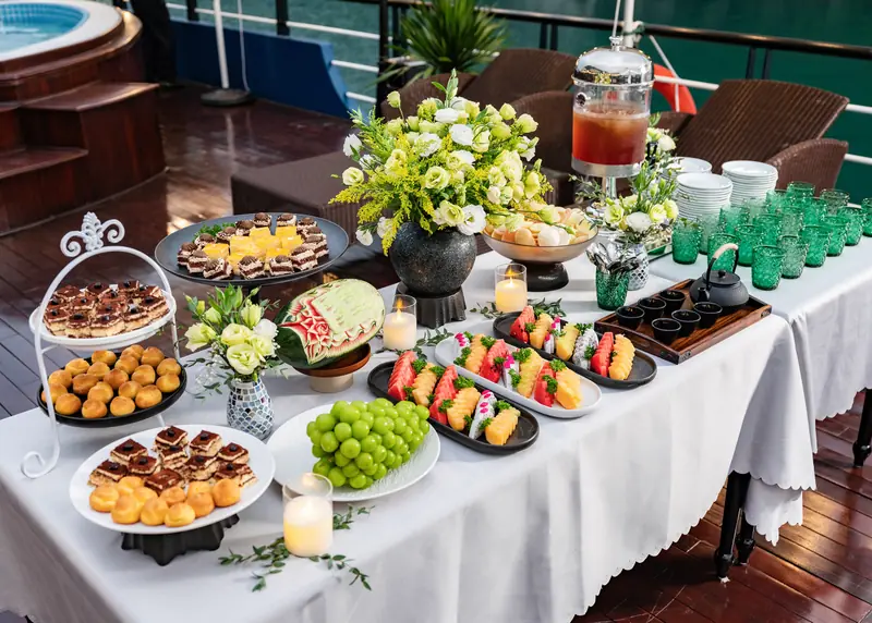 Sunset party fruit and dessert spread on deck