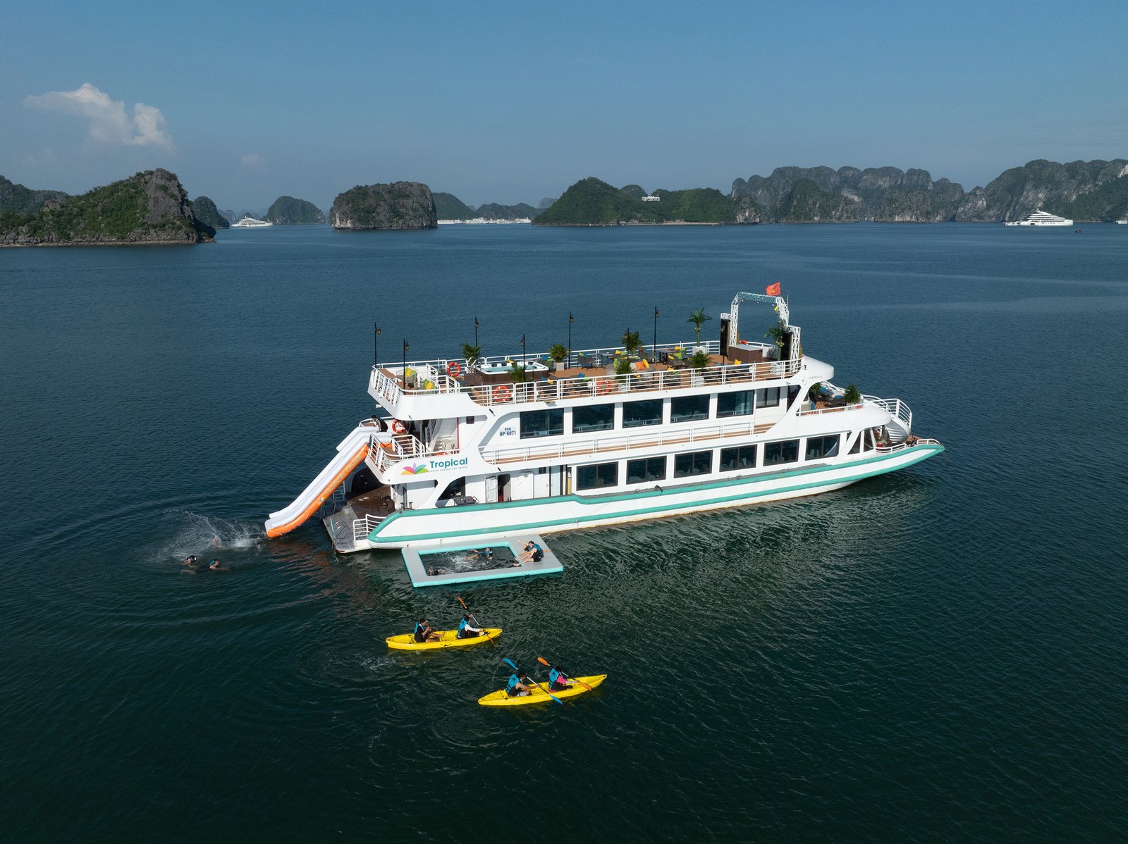 Luftaufnahme der Tropical Cruise mit Wasserrutsche, Kajaks und Karstfelsen der Lan Ha Bay