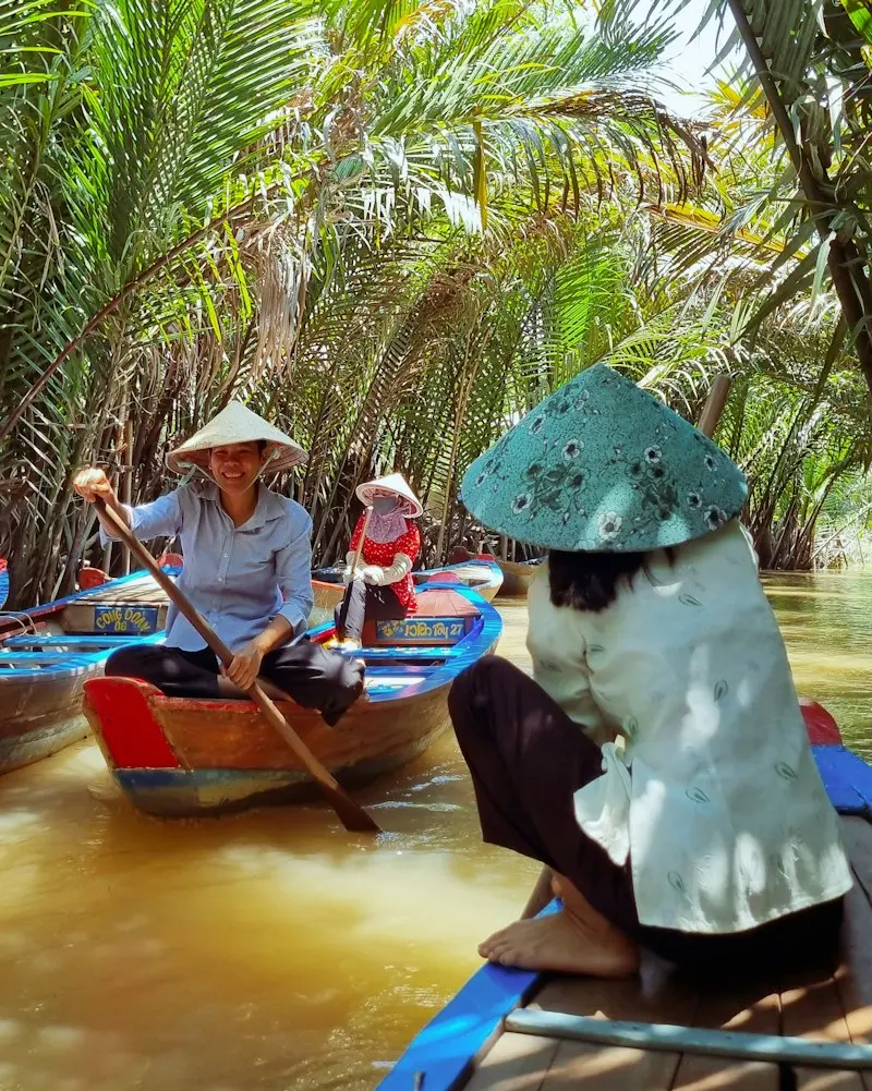 Small boats in a canal lined with water palms