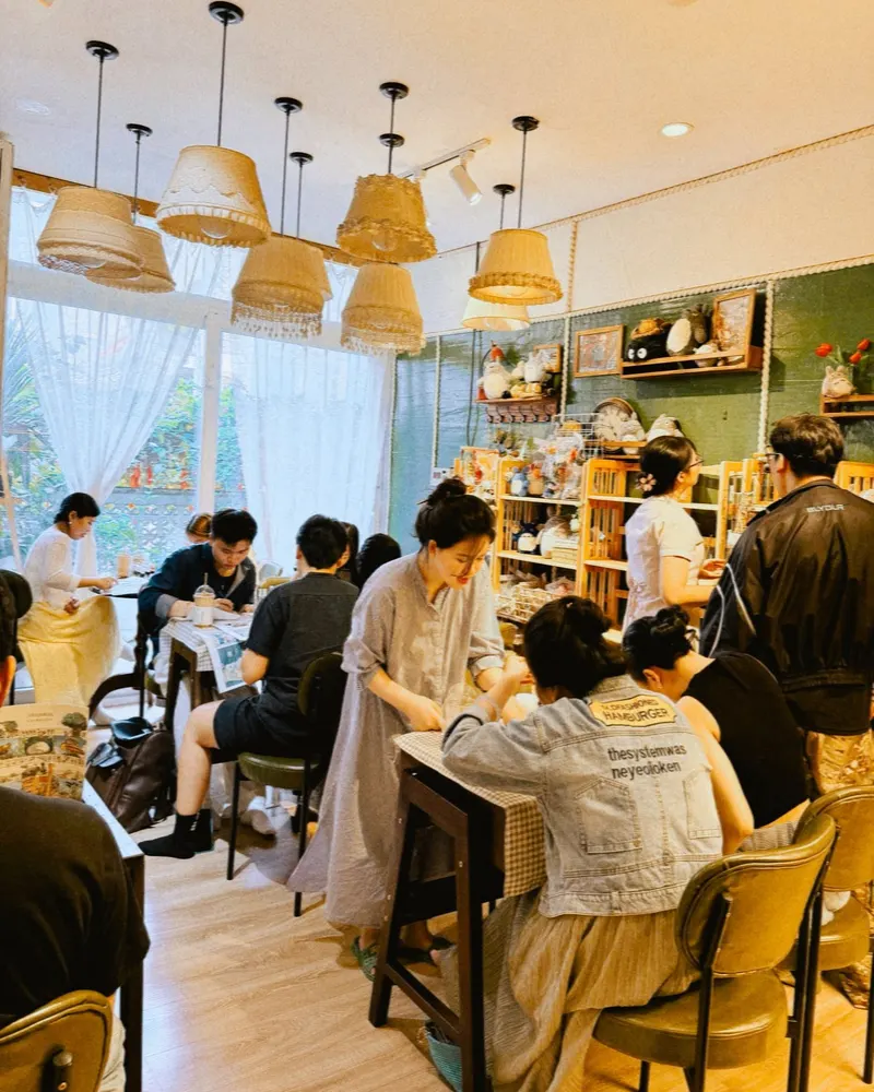 Guests painting at the shared tables in the bright studio
