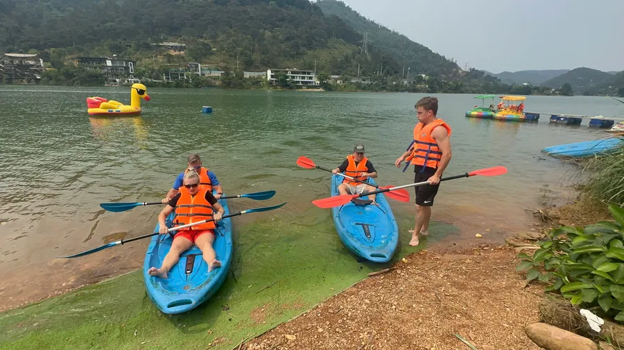 Dos personas en kayak en un lago tranquilo