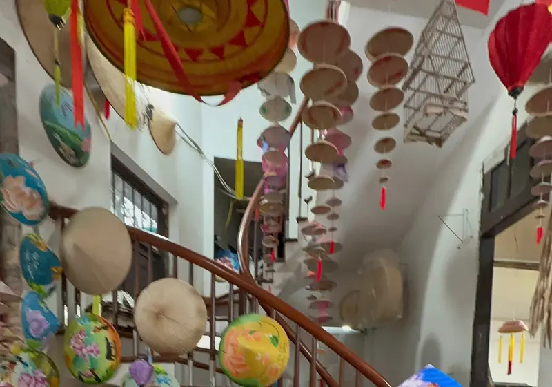 Artisans at work beneath rows of brightly painted conical hats