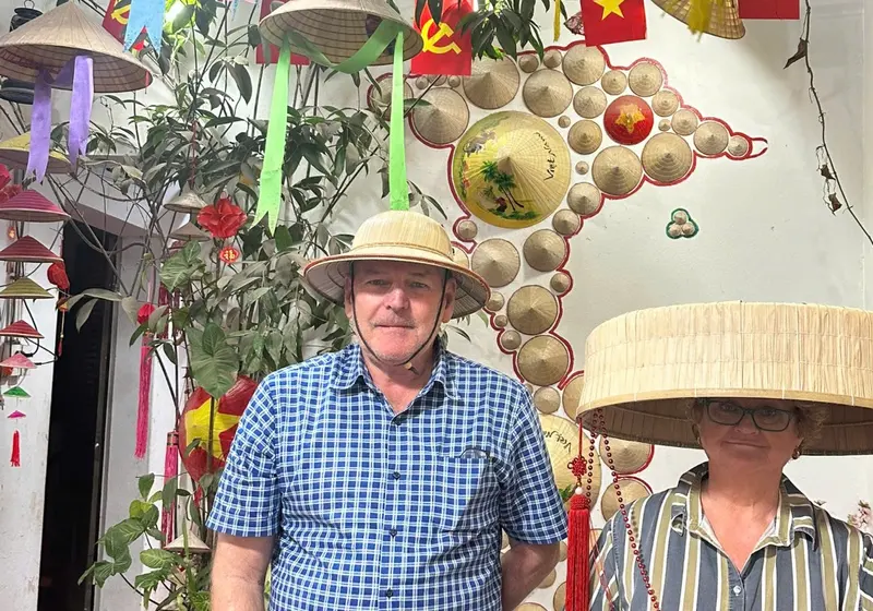 Guests trying a wide conical hat frame in the village shop