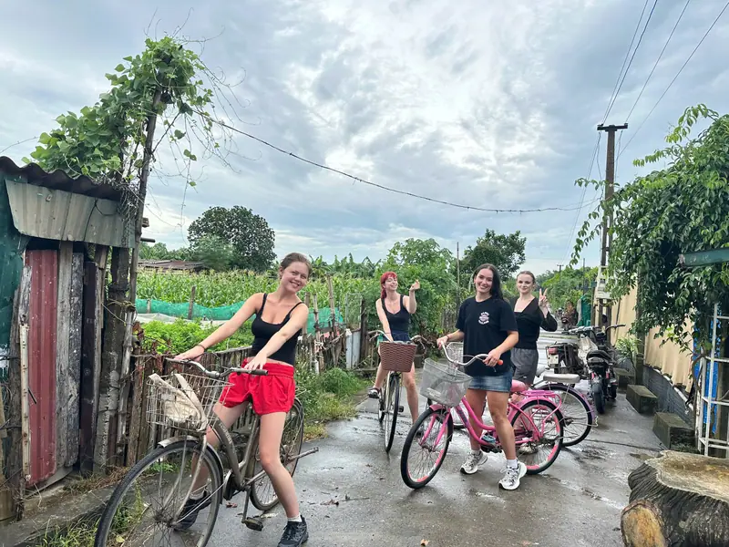 Guests setting off by bicycle down a quiet village lane near Hanoi