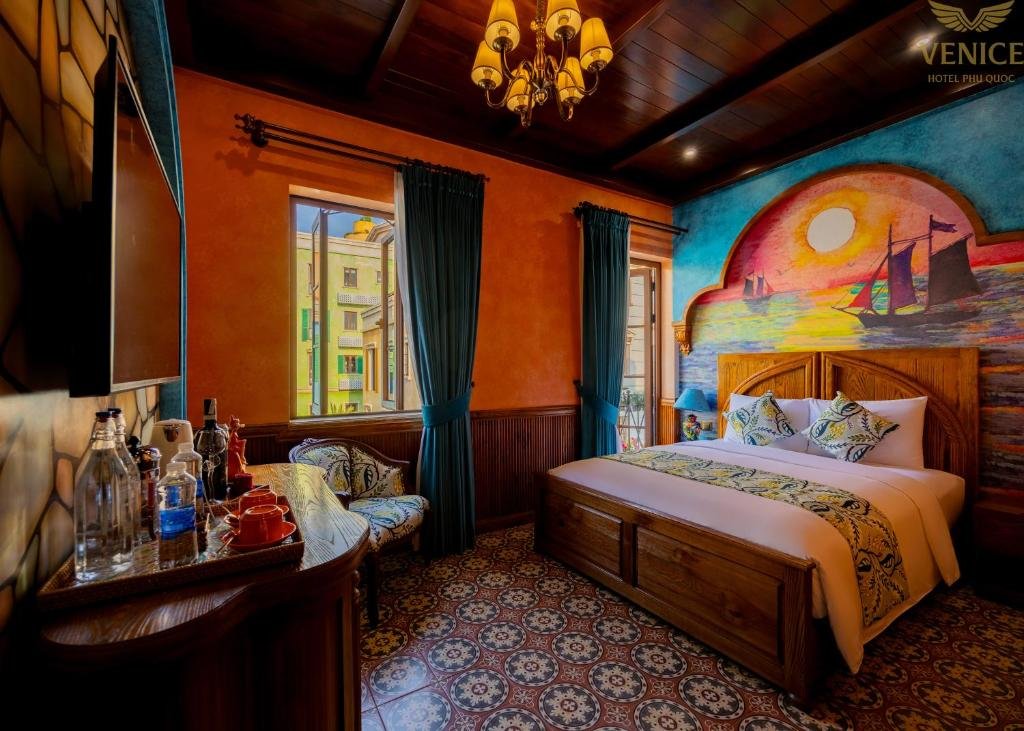 The room with the tea and coffee tray on the console in the foreground, the bed under the sailing-ship mural, and a window and balcony door on the far wall