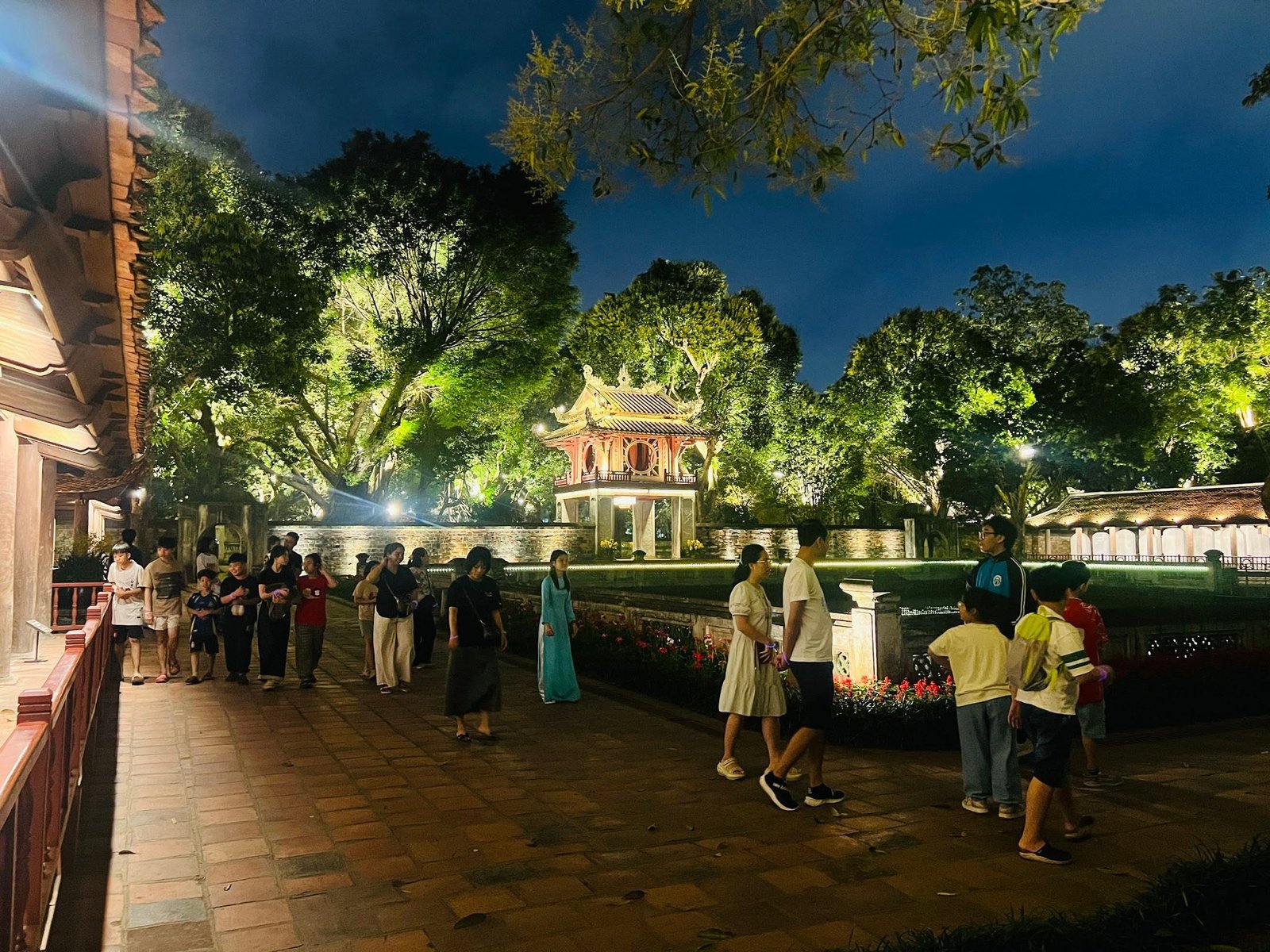 Evening visitors walking through the illuminated grounds