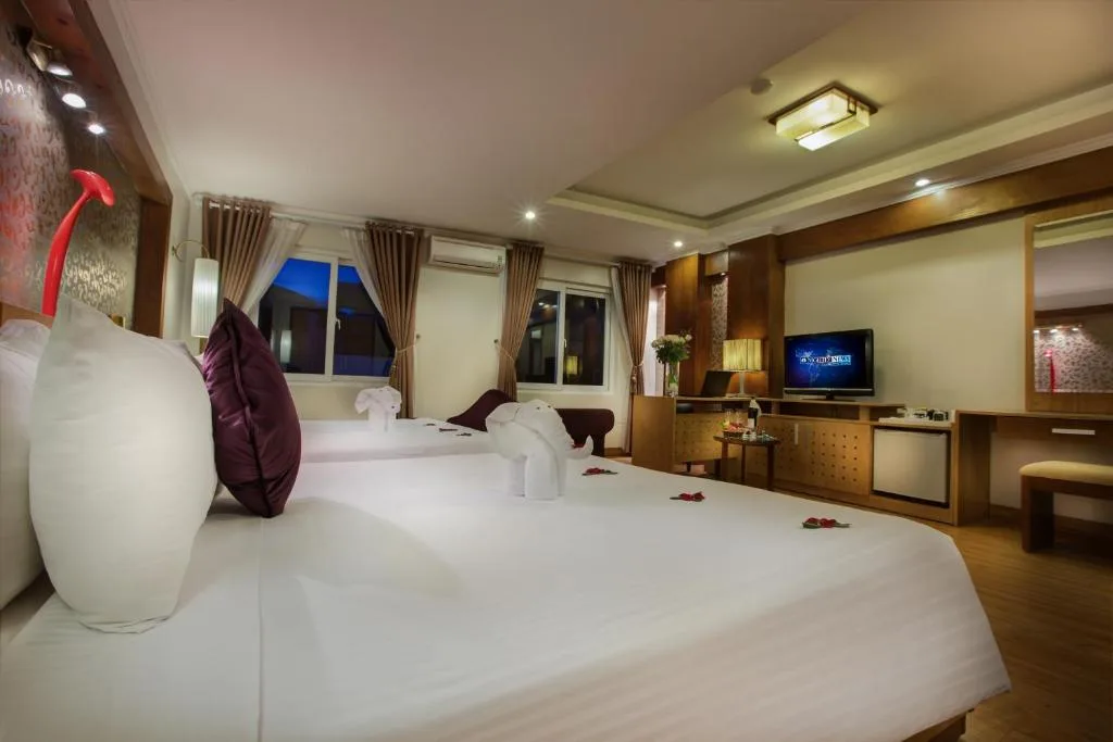 Family room with two beds, a writing desk, a minibar and a bench