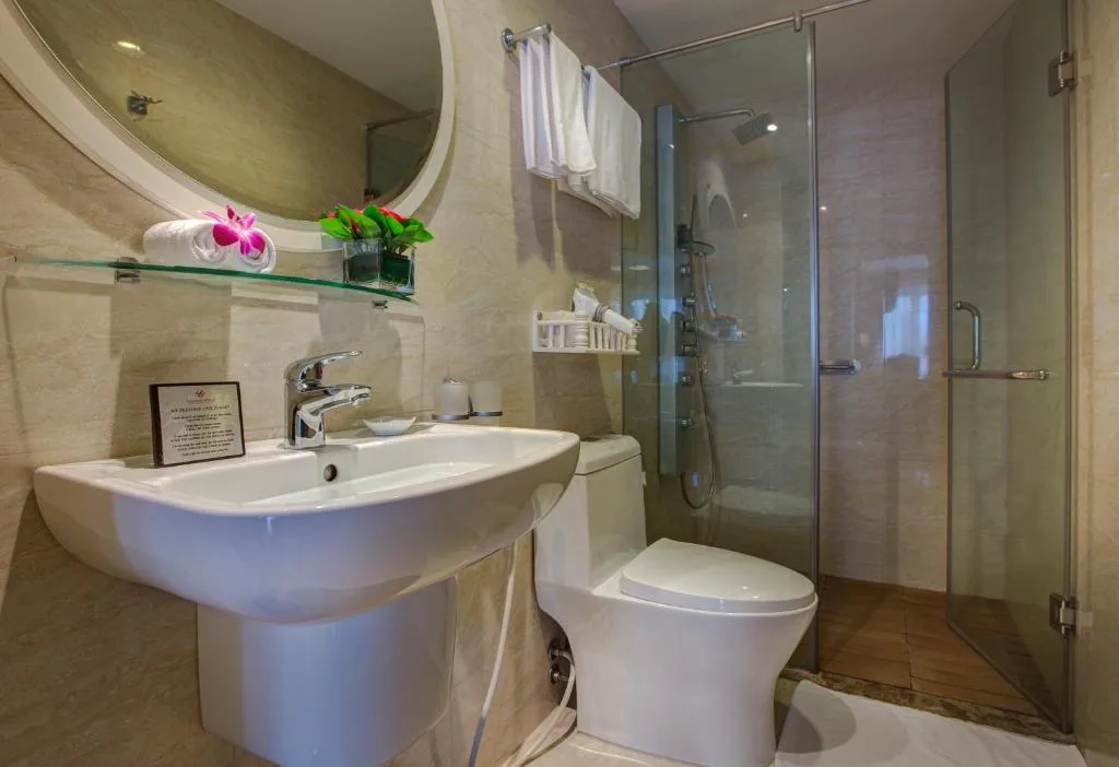 Bathroom with a glass walk-in shower, a wide basin and an oval mirror