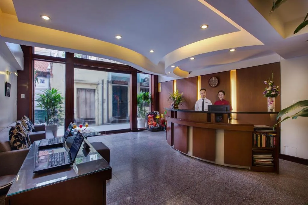 Lobby seating with guest computers on a glass table and reception beyond
