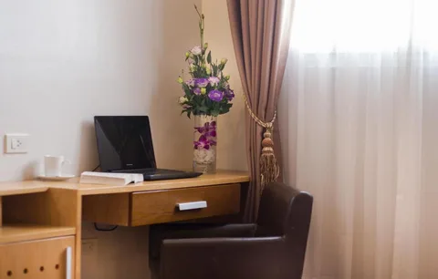 Executive Suite: the writing desk by the window, with a laptop, coffee and fresh flowers
