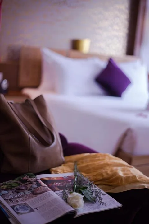 Junior Suite: a magazine and a rose left on the chaise at the foot of the bed