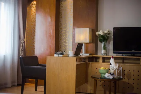 Family Suite: the seating corner, with an armchair, the television and a gold panelled wall
