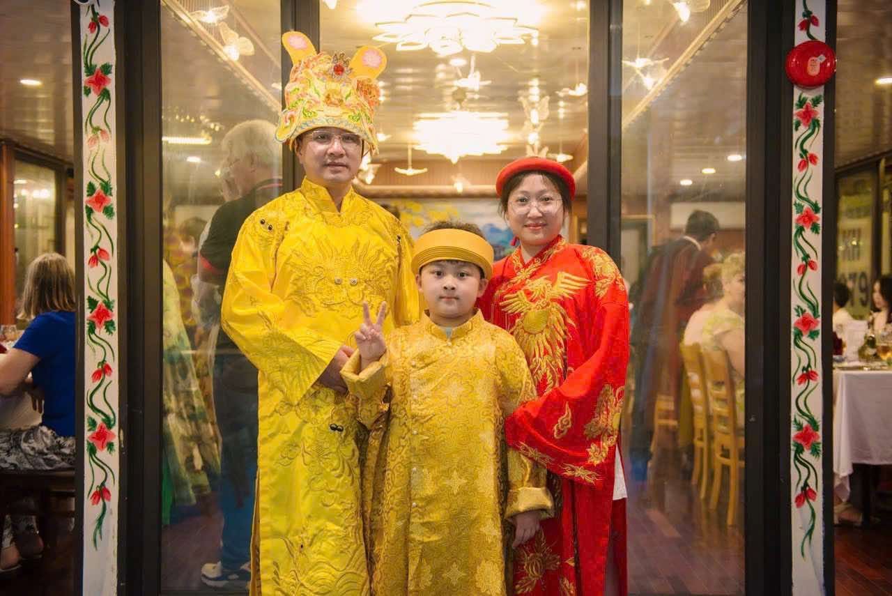A family in imperial yellow and red Huế court robes on the dinner boat