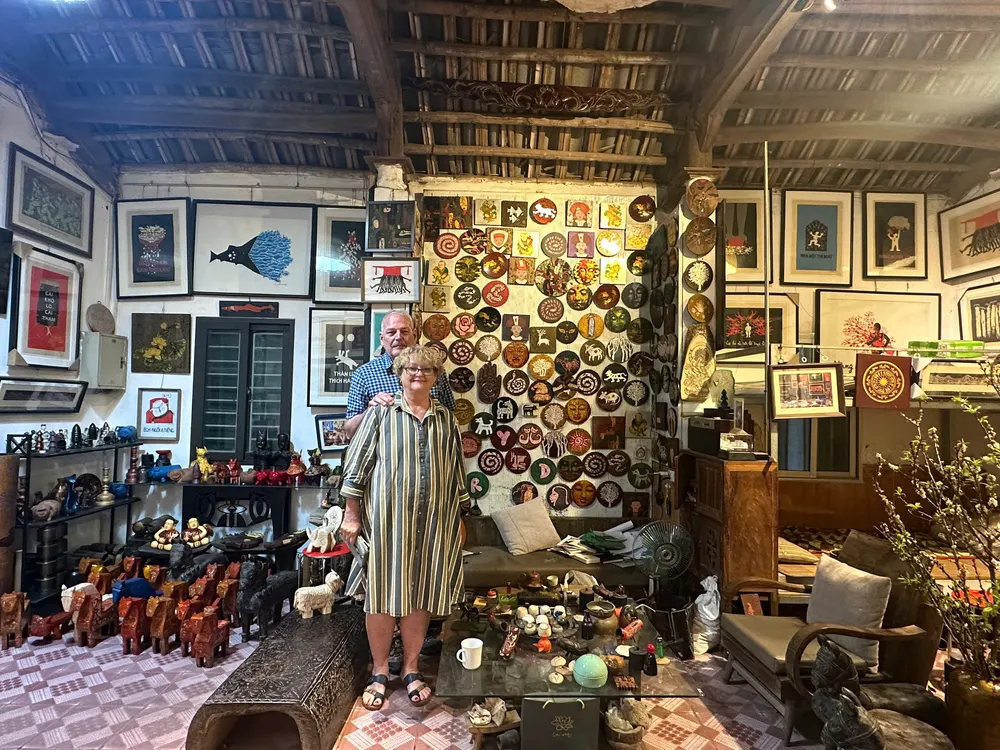 A guest in a Ha Thai lacquer artisan&rsquo;s house, walls covered with lacquered plates and paintings