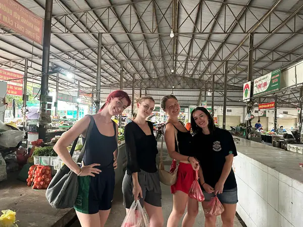 Guests shopping for ingredients in the covered local market