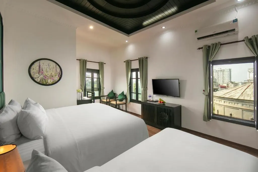 Twin room with two beds and a wide window over the rooftops
