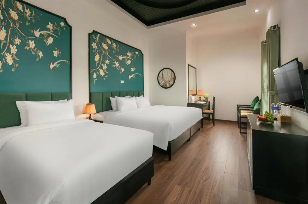 Twin room with two beds under teal painted headboards