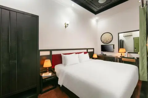 Standard Double: king bed with a red headboard panel and a dark wardrobe