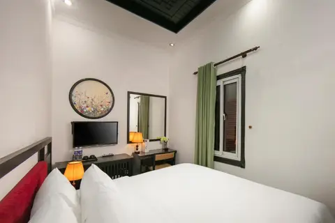Standard Double: bed, television and desk with the window beyond