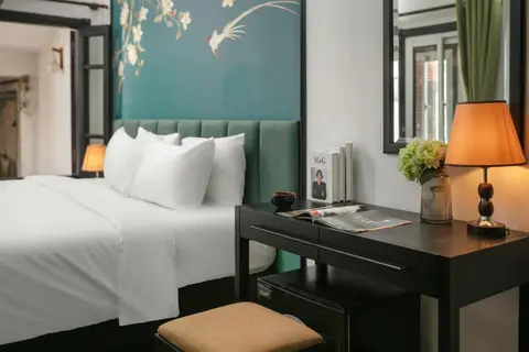 Superior room: writing desk and lamp beside the bed