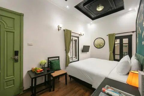 Superior room: the room from the door, with two windows and the green entrance door