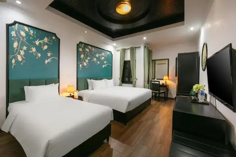 Standard Triple: two beds under painted magnolia headboards, with a coffered ceiling
