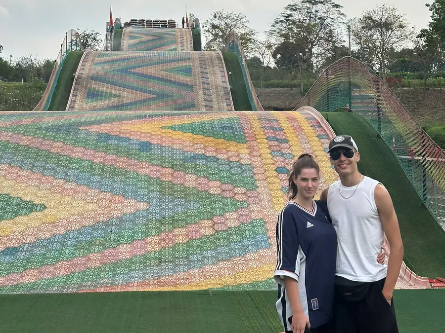 The Rainbow Slide: a wide multicoloured slope with guests standing at the foot of it