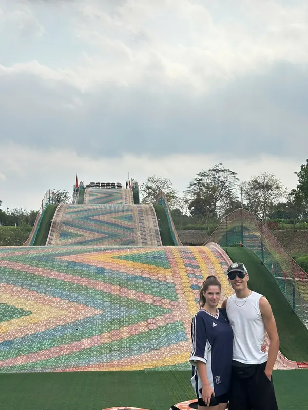 The Rainbow Slide: a wide banked chute in six colours with guests at the foot of the run